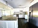 Bright kitchen featuring granite countertops, white cabinets, and stainless steel appliances at 2924 Sylvan Rd, East Point, GA 30344
