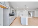 Modern kitchen with gray cabinets, a large island, stainless steel appliances, and hardwood floors at 41 Bennett Farm Dr, Loganville, GA 30052