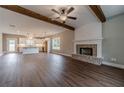 Open-concept living room with wood floors, fireplace, and exposed wood beam ceilings at 63 Youth Jersey Rd, Covington, GA 30014