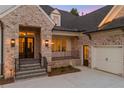 Close-up of the brick home featuring a single car garage and entrance with black framed windows and gas lanterns at 11 Brownson Ct, Acworth, GA 30101