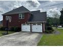 Home featuring an attached two-car garage, basketball hoop and a large driveway for parking at 989 Park Knoll Ct, Lawrenceville, GA 30043