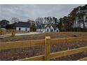 Farmhouse with wooden fence, showcasing its white siding and stone base at 2259 County Line Rd, Acworth, GA 30101