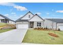Elegant new home boasts a two-car garage, manicured lawn, and classic gray brick exterior at 229 Mooney Rd, Woodstock, GA 30188