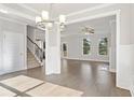 Bright and airy living room featuring hardwood floors, large windows, and modern lighting fixture at 6061 Spring Way, Stonecrest, GA 30038