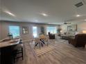 Open-concept living room with wood floors, modern furniture, and large windows providing ample natural light at 3290 Forest Green Dr, Douglasville, GA 30135