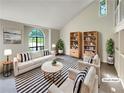 Bright, staged living room with vaulted ceiling and a large window at 320 Rebecca Lake Way, Fairburn, GA 30213