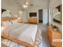 Staged main bedroom with a ceiling fan, light wood furniture and ensuite at 320 Rebecca Lake Way, Fairburn, GA 30213