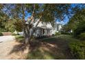 A quaint property showcases a lovely covered porch and verdant lawn shaded by mature trees at 150 E Main St, Rutledge, GA 30663