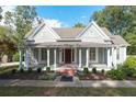 Inviting home featuring a covered front porch with columns and a red door, surrounded by manicured landscaping at 150 E Main St, Rutledge, GA 30663