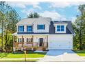 Charming two-story home with a covered front porch, attached garage, and well-manicured lawn at 6462 Beaver Creek Trl, Atlanta, GA 30349