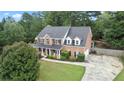 Well-maintained brick home with lush green lawn, mature trees, and long driveway, perfect for outdoor enjoyment at 1500 Terminal Ct, Mcdonough, GA 30252