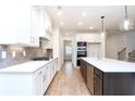 Modern kitchen featuring white cabinets, stainless steel appliances, quartz countertops and recessed lighting at 1254 Red Oak Blvd, Loganville, GA 30052