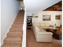 Inviting living area with plush beige carpeting, modern staircase, and a comfortable cream-colored sectional sofa at 840 Brandy Oaks Ln, Stone Mountain, GA 30088