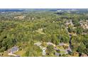 Aerial view of home, showcasing wooded lot, neighborhood, and surrounding trees at 1210 Swan Mill Ct, Suwanee, GA 30024