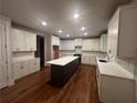 Bright kitchen featuring a center island, white cabinets, and hardwood floors at 337 Willow Cv, Canton, GA 30114