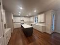 Bright kitchen featuring a center island, white cabinets, and hardwood floors at 337 Willow Cv, Canton, GA 30114