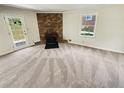 Living room with fireplace, neutral carpet, and view of the backyard at 211 Murphy Ave, Lawrenceville, GA 30044