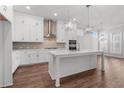Bright kitchen with white cabinets, stainless steel appliances, a center island, and a stylish backsplash at 482 Broom Dr, Cumming, GA 30040