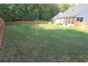 Spacious backyard with green grass and a wooden privacy fence at 3406 Ravensworth Nw Trce, Kennesaw, GA 30144