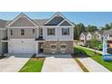 Two-story townhome with gray and beige siding, two-car garage, and landscaping at 133 Stanchion Dr, Union City, GA 30291