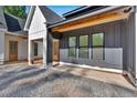 Modern farmhouse exterior showcasing grey board and batten, black window frames, and a side entry at 107 Marks Way, Canton, GA 30115