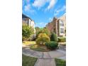 A beautiful landscaped courtyard features lush greenery and manicured trees surrounding elegant townhomes at 4853 Stonehall Pl, Atlanta, GA 30339