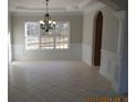 Elegant dining room features neutral colors, wainscoting, and a stylish chandelier over tile flooring at 354 Mansfield Way, Stockbridge, GA 30281