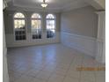 Charming dining room with paneled wainscoting, three arched windows, and neutral tile flooring at 354 Mansfield Way, Stockbridge, GA 30281