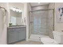 Modern bathroom featuring a glass-enclosed shower, granite vanity, and neutral-toned tile at 5225 Maggie Mae Ln, Cumming, GA 30028