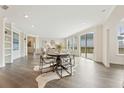 Open-concept living and dining area with hardwood floors, modern lighting, and ample natural light at 5225 Maggie Mae Ln, Cumming, GA 30028
