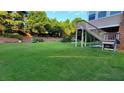 Expansive backyard with lush green grass, wooden staircase and mature trees providing privacy at 3450 Camellia Ln, Suwanee, GA 30024