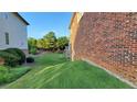 Brick house with a well-maintained lawn and mature trees next to a neighboring house at 3450 Camellia Ln, Suwanee, GA 30024