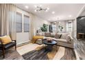 Bright living room with large windows, sectional sofa, and a neutral color palette at 648 Glendale Rd, Scottdale, GA 30079