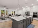 Bright open-concept kitchen with white cabinets, an island with quartz countertops, and stainless steel appliances at 1070 Harper Dr, Alpharetta, GA 30076