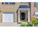Welcoming front door entrance featuring classic columns, pumpkins, and a one-car garage with brick facade at 3676 Chattahoochee Summit Dr, Atlanta, GA 30339