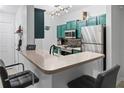 Modern kitchen with stainless steel appliances, breakfast bar, and stylish hanging light fixture at 2700 Pine Tree Ne Rd # 2108, Atlanta, GA 30324