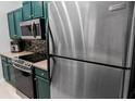 Close-up of kitchen featuring stainless steel appliances and trendy green cabinets at 2700 Pine Tree Ne Rd # 2108, Atlanta, GA 30324