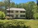 Traditional two-story home with green shutters, a manicured lawn, and mature trees around property at 26 Flint Ridge Se Dr, Mableton, GA 30126