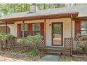 View of the cozy front porch with lattice trim and red shutters, next to an attached garage at 798 Tommy Lee Cook Rd, Palmetto, GA 30268