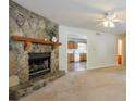 Inviting living room featuring a stunning stone fireplace and an open doorway to the kitchen at 798 Tommy Lee Cook Rd, Palmetto, GA 30268