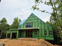 Exterior view of home under construction featuring black window frames and wrapped in green sheathing at 170 Cedarwood Ln, Roswell, GA 30075