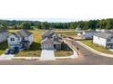Aerial view of a grey two-story home featuring a two car garage, landscaping, sidewalks and green spaces at 1857 Holmsey Cir, Conyers, GA 30094