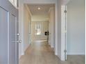 Bright hallway with hardwood floors leads to an open-concept living space with a modern fireplace and natural light at 125 Belvedere Rd, Mcdonough, GA 30253