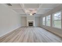 Spacious living room with a stone fireplace, coffered ceiling, and hardwood floors at 4443 Eastbrook Pl, Snellville, GA 30039