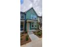 Inviting two-story townhome featuring a vibrant exterior, covered entrance, and beautifully landscaped front yard at 1095 Tucker Ave # 203, Atlanta, GA 30310