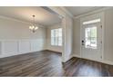 Living room with wainscoting, window, hard wood floors and chandelier at 409 West March Cir, Loganville, GA 30052