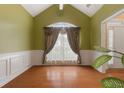 Dining room featuring hardwood floors, wainscoting and a window with elegant curtains at 532 Goldfinch Way, Stockbridge, GA 30281