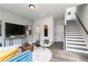 Open-concept living room with hardwood floors and staircase access at 373 Skylar Se Way, Atlanta, GA 30315