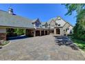 A stunning home featuring a stone and stucco facade, a porte-cochere, and a spacious driveway at 6308 Woodlake Dr, Buford, GA 30518