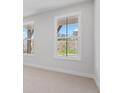 Bright bedroom with neutral carpet, natural light through windows, and partial view of a landscaped backyard at 7530 Homer Dr, Cumming, GA 30028
